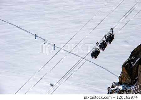 Spectacular view from the Aiguille du Midi observation deck, triple gondola and alpinists, Chamonix, France 120562974