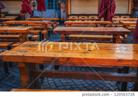 wooden tables and benches in a street cafe in evening in the rain wooden tables and benches in a street cafe in evening in the rain 120563726