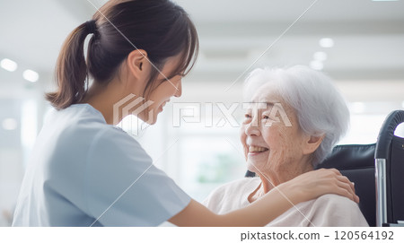 微笑的護士為坐在輪椅上的老年婦女提供情感支持 微笑的護士為坐在輪椅上的老年婦女提供情感支持 120564192
