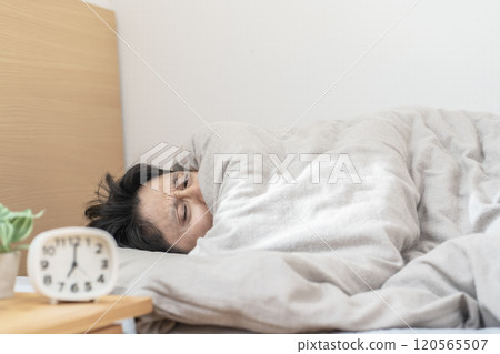 在床上睡覺的男人。 120565507