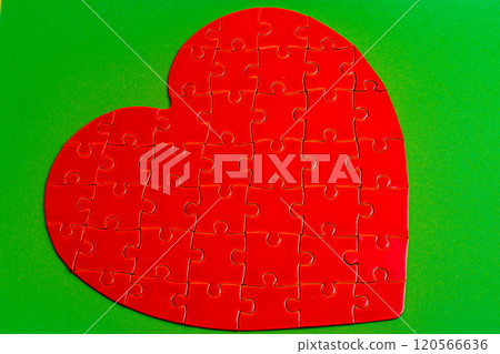 Feelings concept. Heart puzzle on green background 120566636