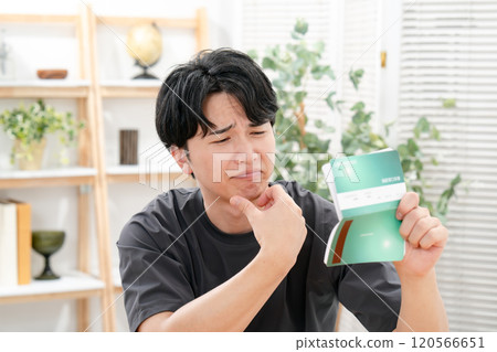 A worried man holding a bankbook A worried man holding a bankbook 120566651