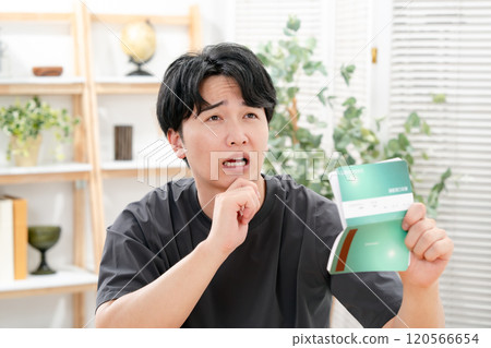 A worried man holding a bankbook A worried man holding a bankbook 120566654