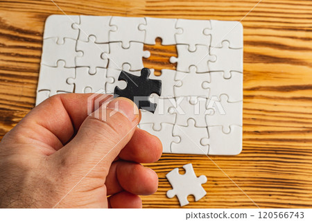Hands holding black and white puzzle, concept of difficult option choice 120566743