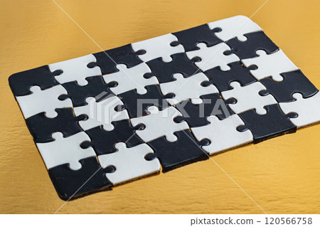 Black and white puzzle, teamwork challenge concept on gold background Black and white puzzle, teamwork challenge concept on gold background 120566758