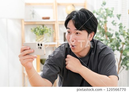 A man laughing at a smartphone 120566770