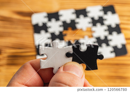 Hands holding black and white puzzle, concept of difficult option choice 120566780