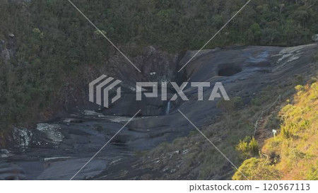 Serene Waterfall on Rocky Slope in Lush Forest 120567113
