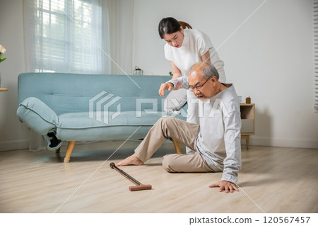 Asia young woman halping her father after falling down on floor, elderly old man with walking stick fall on ground and daughter camp to help at home in living room, family health care 120567457