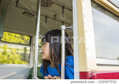 A girl in blue clothes sitting on a retro bus 120567550
