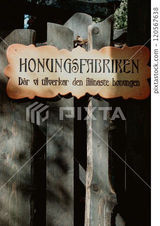Honey factory sign attached to a wooden gate 120567638