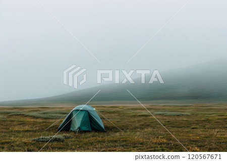 Tent pitched in a misty meadow on a foggy morning 120567671