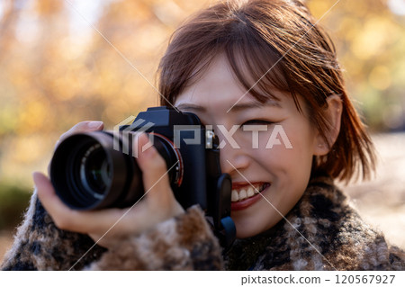Camera girl shooting autumn leaves 120567927