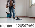 Person Vacuuming Floor with Modern Vacuum Cleaner in Clean, Minimalistic Room 120567969