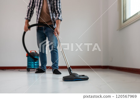 Person Vacuuming Floor with Modern Vacuum Cleaner in Clean, Minimalistic Room Person Vacuuming Floor with Modern Vacuum Cleaner in Clean, Minimalistic Room 120567969