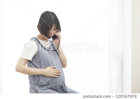 Image of a pregnant woman having a phone consultation (stock photo) Image of a pregnant woman having a phone consultation (stock photo) 120567978