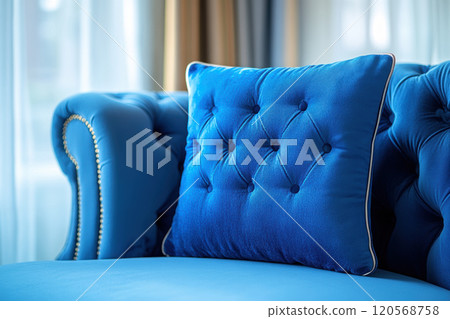 Luxurious blue velvet throw pillow on stylish couch, adding elegance and comfort to living space. Perfect for enhancing interior decor 120568758