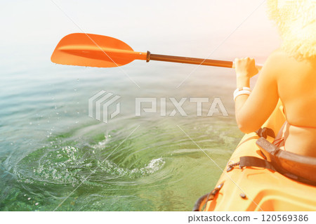 Kayak paddle sea vacation. Person paddles with orange paddle oar on kayak in sea. Leisure active lifestyle recreation activity rest tourism travel 120569386