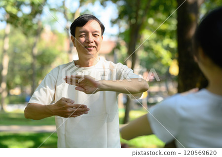 Smiling middle age man practicing Tai Chi in the morning. Mental health and well-being.concept 120569620