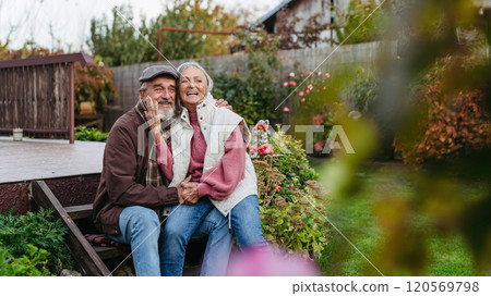 Portrait of beautiful senior couple outdoors in an autumn garden. Elderly husband and wife are embracing each other. Portrait of beautiful senior couple outdoors in an autumn garden. Elderly husband and wife are embracing each other. 120569798