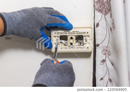 Electrician is fixing old sockets of a residential. 120569905