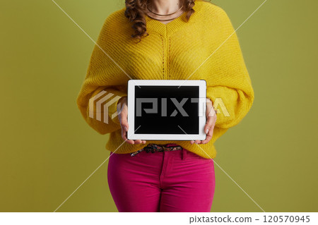 Healthy 40 years old woman showing tablet PC against green Healthy 40 years old woman showing tablet PC against green 120570945