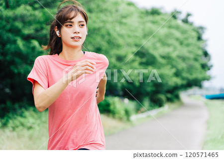 A woman jogging while listening to music A woman jogging while listening to music 120571465