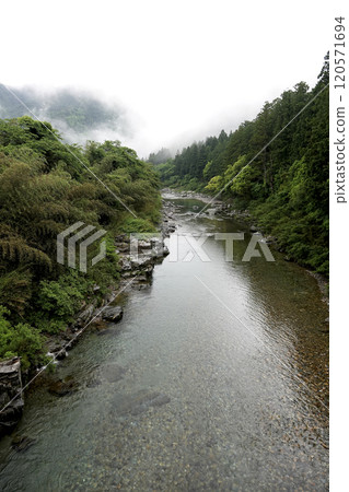 美麗的山間溪流,山巒薄霧,綠意盎然 美麗的山間溪流,山巒薄霧,綠意盎然 120571694