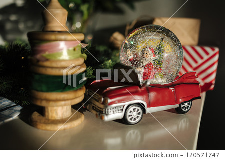 Retro toy Santa car on Christmas gifts. Snow globe with Santa  120571747