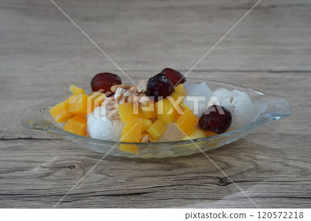 side view Coconut milk ice cream topped with coconut jelly, nuts, dried puttha, and welded in a glass bowl, on wooden floor background, object, food, dessert, sweet, copy space side view Coconut milk ice cream topped with coconut jelly, nuts, dried puttha, and welded in a glass bowl, on wooden floor background, object, food, dessert, sweet, copy space 120572218