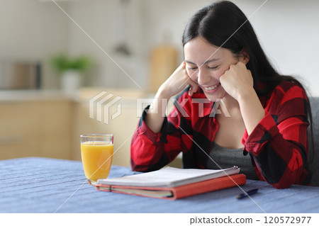 Happy asian student studying in the kitchen 120572977