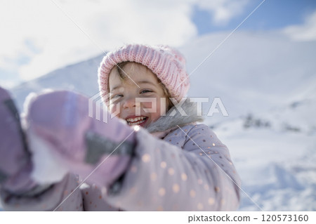 Portrait of small girl enjoying winter holiday in the mountains with family, playing in snow. Portrait of small girl enjoying winter holiday in the mountains with family, playing in snow. 120573160