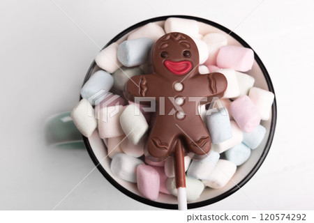 Chocolate man on marshmallow cup, sweet Christmas cookies, close-up, top view Chocolate man on marshmallow cup, sweet Christmas cookies, close-up, top view 120574292