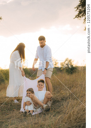 Happy young family dad, mom and two children playing outdoors, having fun on a day off. Happy young family dad, mom and two children playing outdoors, having fun on a day off. 120575204