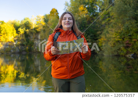 Traveling Happy Caucasian woman with backpack walking on path the mountain forest looking at the camera and map. Summer holiday and vacation trip Traveling Happy Caucasian woman with backpack walking on path the mountain forest looking at the camera and map. Summer holiday and vacation trip 120575357