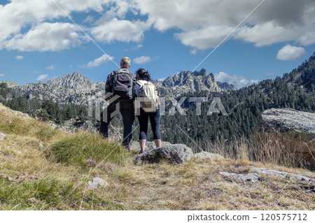 Middle aged tourist couple looking forward to landscape, Mountain Pyrenees of Spain Middle aged tourist couple looking forward to landscape, Mountain Pyrenees of Spain 120575712