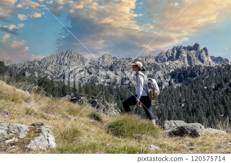 Female middle aged Spanish tourist walking by Spanish Pyrenees mountain during sunny day 120575714