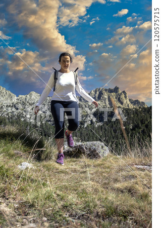 Female middle aged Spanish tourist walking by Spanish Pyrenees mountain during sunny day Female middle aged Spanish tourist walking by Spanish Pyrenees mountain during sunny day 120575715