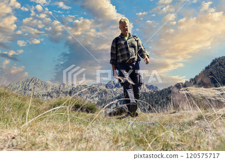 Male middle aged caucasian tourist walking by Spanish Pyrenees mountain during sunny day Male middle aged caucasian tourist walking by Spanish Pyrenees mountain during sunny day 120575717