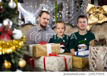 Happy father with children celebrating Christmas and giving each other gifts 120575934