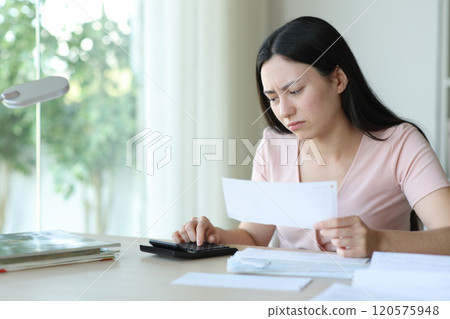 Worried asian woman calculating holding invoice 120575948
