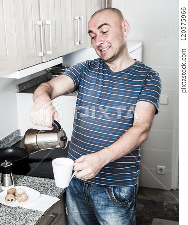 European guy pours coffee into cup of coffee pot 120575966