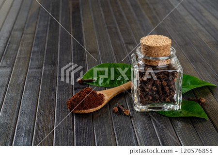 Whole and ground cloves spice over dark wooden background. 120576855