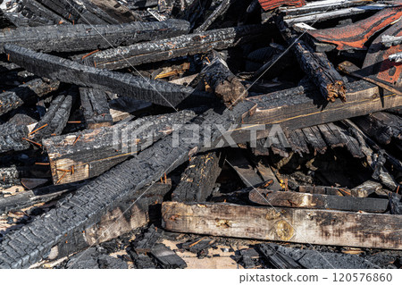 Heap of charred wooden boards after the fire. Pile of burnt wood planks. Heap of charred wooden boards after the fire. Pile of burnt wood planks. 120576860