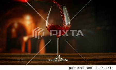 Close-up of red wine pouring into glass in wine cellar , freeze motion. 120577318