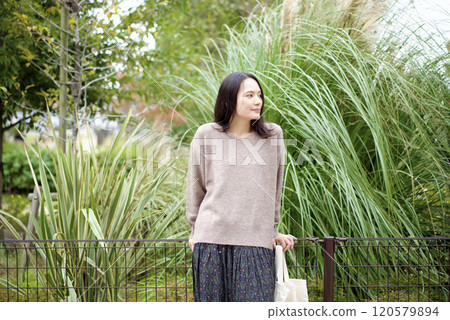 A woman standing with plants in the background 120579894