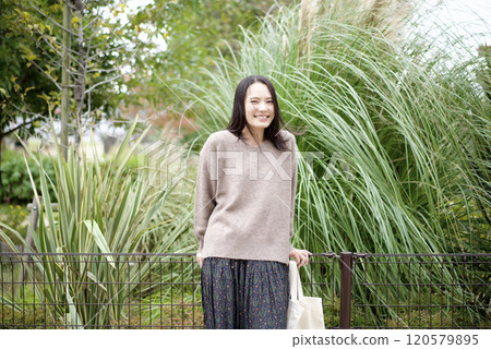 A woman standing with plants in the background 120579895