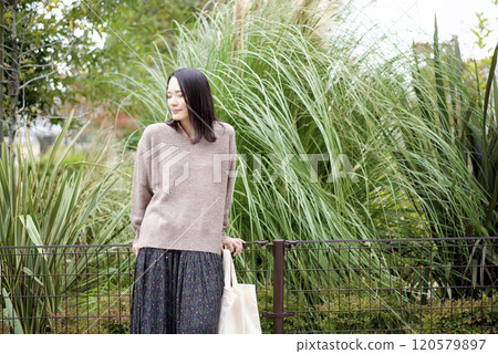 A woman standing with plants in the background 120579897