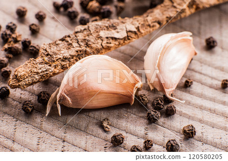 garlic on wooden surface.White garlic bulbs and peeled garlic in ceramic bowl on rough green old wooden background. garlic on wooden surface.White garlic bulbs and peeled garlic in ceramic bowl on rough green old wooden background. 120580205