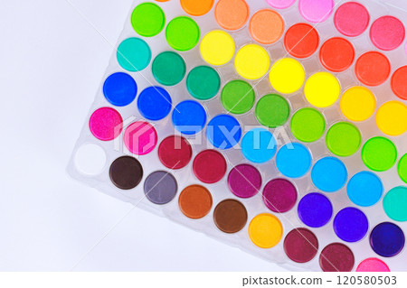 Artists hobbyists essential tools, colorful paints palette of watercolors arranged in rainbow of colors, ready for inspiration. 120580503
